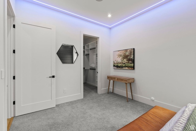 bedroom featuring carpet floors, baseboards, a walk in closet, and a closet