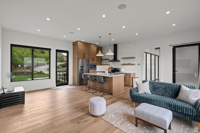living area featuring light wood-type flooring and recessed lighting