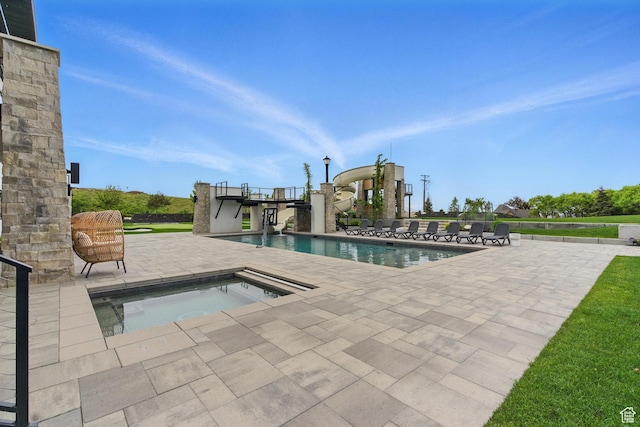 swimming pool featuring a patio area and an in-ground hot tub