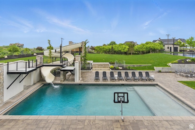 swimming pool featuring a patio and a yard