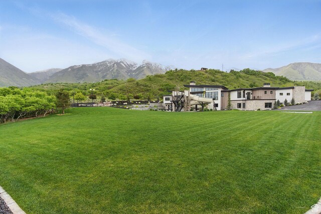 view of green lawn with a mountain view