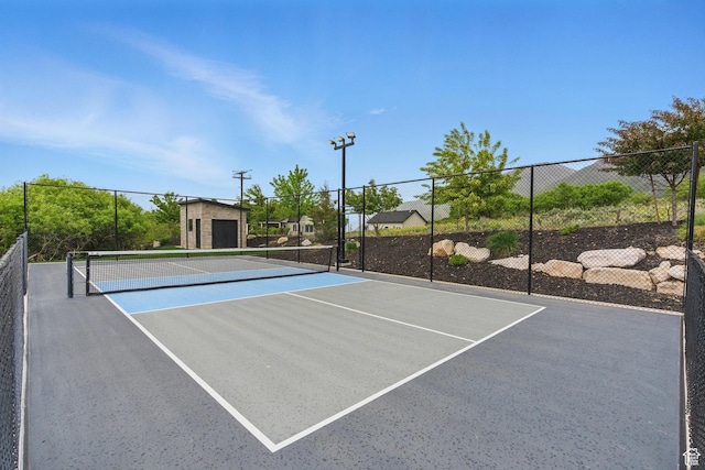 view of tennis court featuring fence and community basketball court