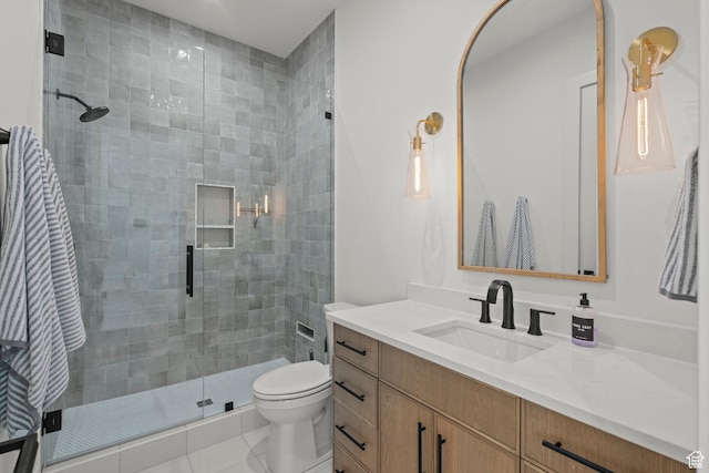 bathroom with a shower stall, toilet, vanity, and tile patterned floors