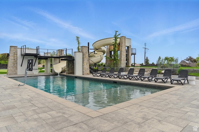 swimming pool featuring a water slide and a patio