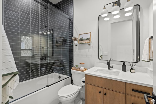 bathroom with vanity, combined bath / shower with glass door, and toilet
