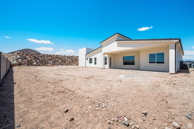 back of house featuring stucco siding and fence