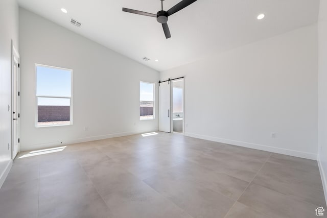 empty room featuring a ceiling fan, concrete flooring, lofted ceiling, baseboards, and a barn door