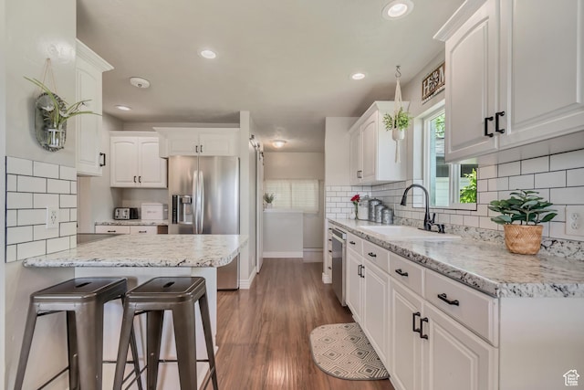 120 N 5th St, Tooele, UT 84074 - kitchen featuring stainless steel appliances, a sink, baseboards, white cabinets, and recessed lighting