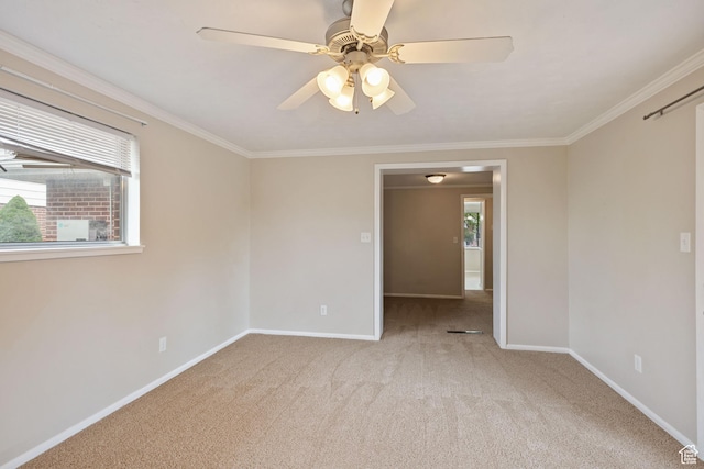 empty room with baseboards, light carpet, crown molding, and a ceiling fan