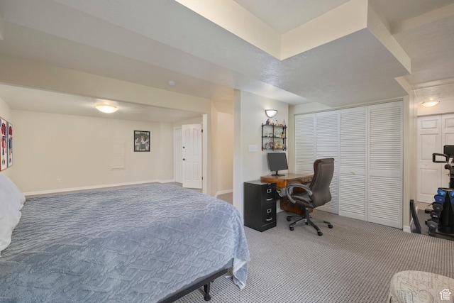 carpeted bedroom with baseboards and a desk