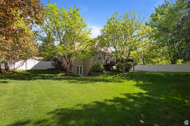 view of yard featuring french doors and a deck