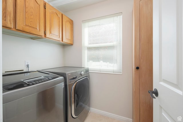 laundry room featuring washing machine and clothes dryer, cabinet space, and baseboards