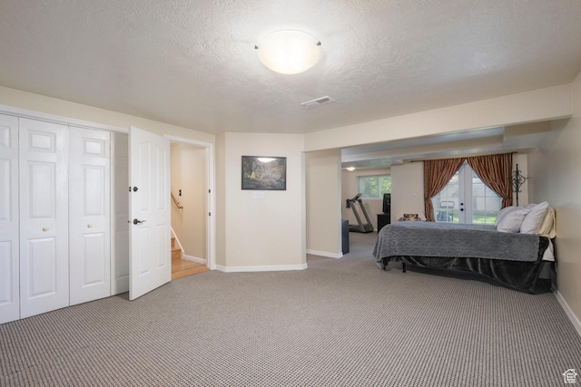 bedroom with carpet, french doors, baseboards, a textured ceiling, and a closet