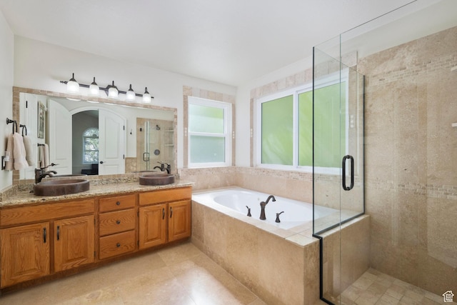full bathroom featuring a shower stall, a garden tub, double vanity, and tile patterned flooring