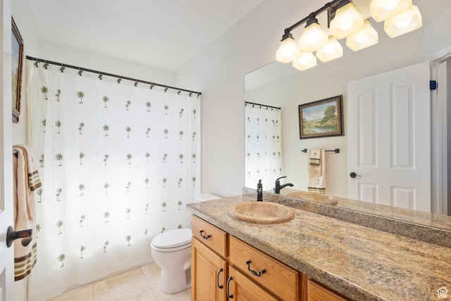 bathroom with toilet, vanity, and tile patterned flooring