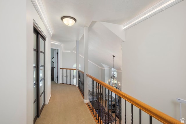 corridor featuring a chandelier, light colored carpet, and an upstairs landing