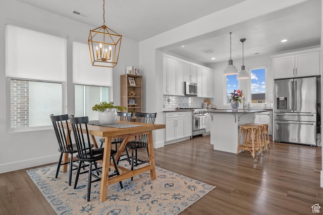 dining room featuring a chandelier, recessed lighting, dark wood-style flooring, and baseboards