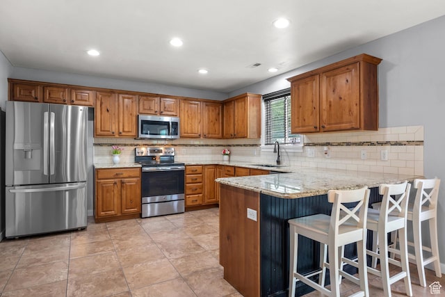 1066 W 1325 S, Springville, UT 84663 - kitchen with appliances with stainless steel finishes, a sink, brown cabinetry, a peninsula, and tasteful backsplash