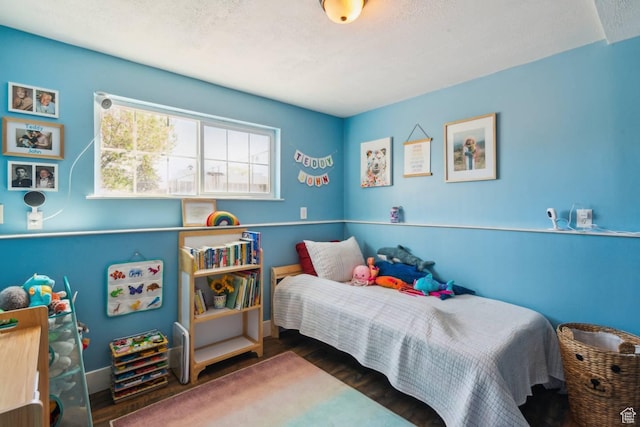 bedroom featuring wood finished floors and baseboards
