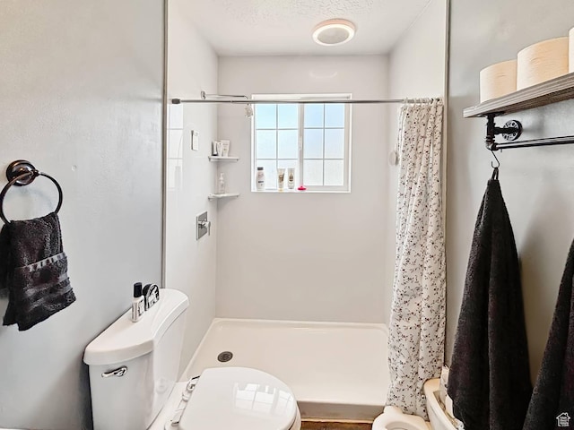 full bath featuring toilet and a stall shower