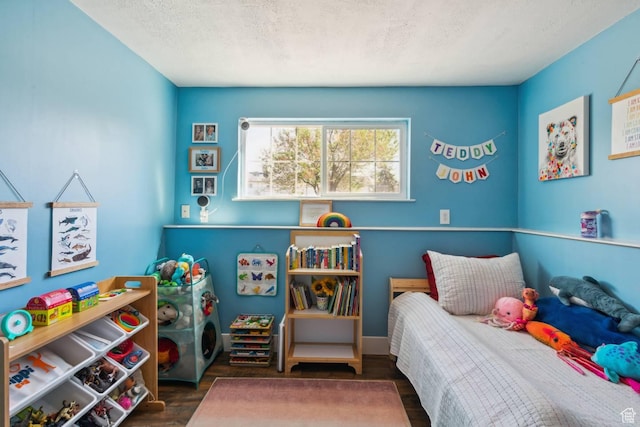 bedroom with wood finished floors and a textured ceiling