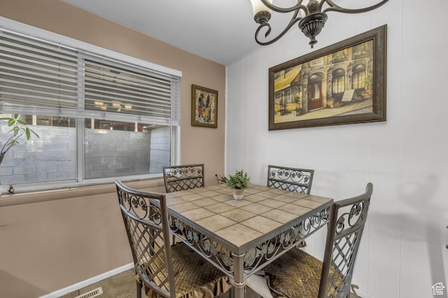 dining area featuring a chandelier and baseboards