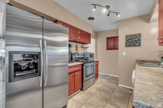 kitchen featuring appliances with stainless steel finishes, light tile patterned flooring, a sink, and light countertops