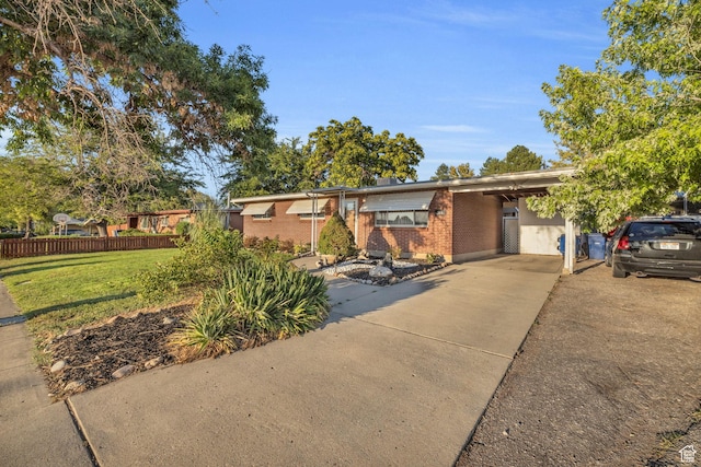 single story home featuring brick siding, concrete driveway, and an attached carport