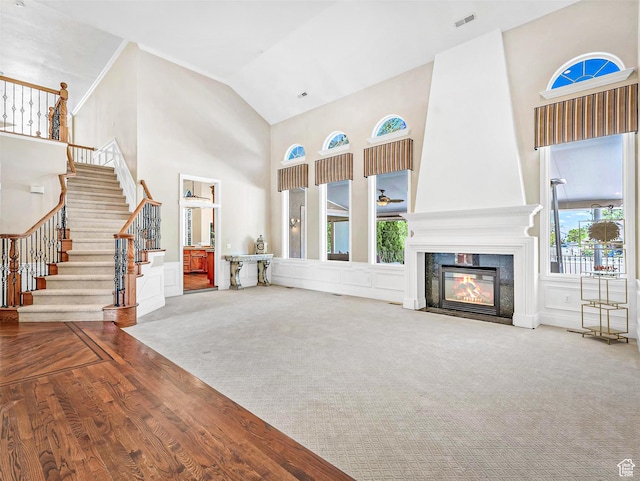 10868 S Prescott Dr E, Sandy, UT 84092 - unfurnished living room with high vaulted ceiling, stairway, a high end fireplace, wood finished floors, and carpet floors