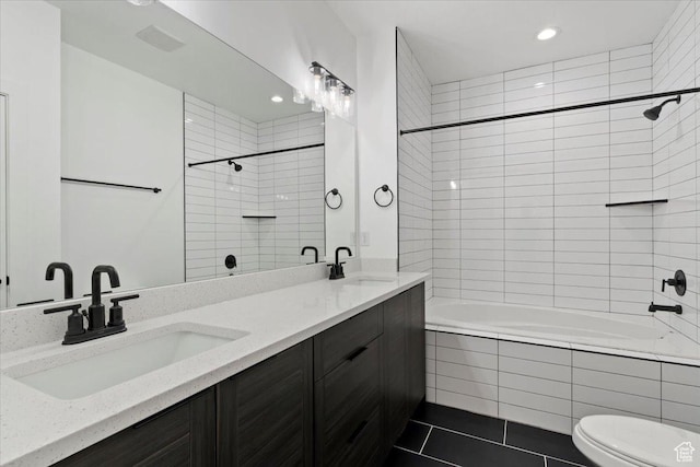full bathroom with tiled shower / bath combo, double vanity, toilet, recessed lighting, and tile patterned flooring