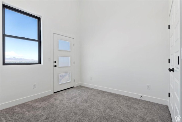 carpeted foyer with baseboards