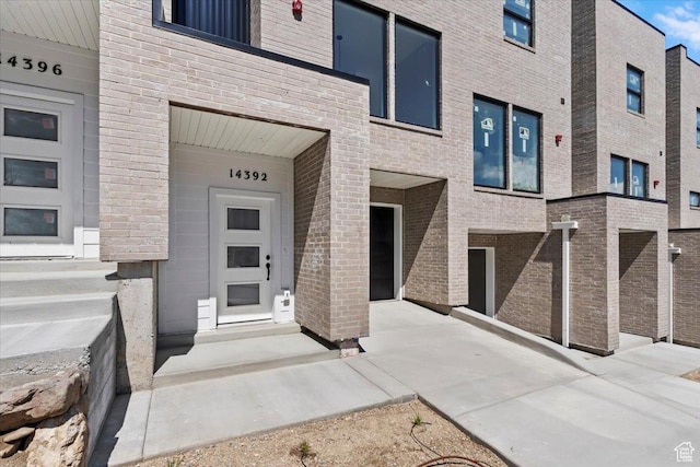 view of exterior entry featuring brick siding