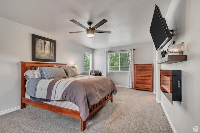 carpeted bedroom featuring baseboards, ceiling fan, and a textured ceiling