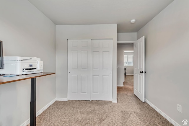 unfurnished bedroom featuring carpet flooring, baseboards, and a closet