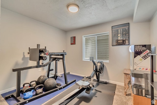 workout room with a textured ceiling and baseboards
