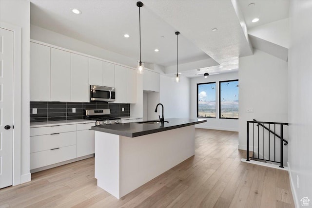 kitchen featuring a sink, stainless steel appliances, modern cabinets, white cabinetry, and recessed lighting