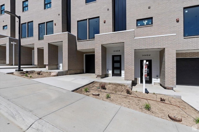 view of front facade featuring brick siding and driveway