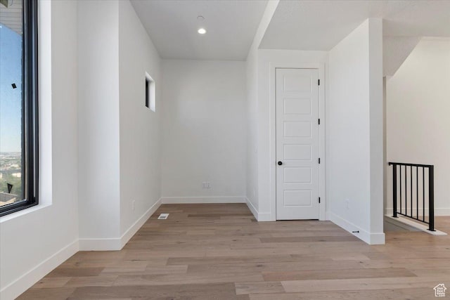 unfurnished room with wood finished floors, baseboards, and recessed lighting
