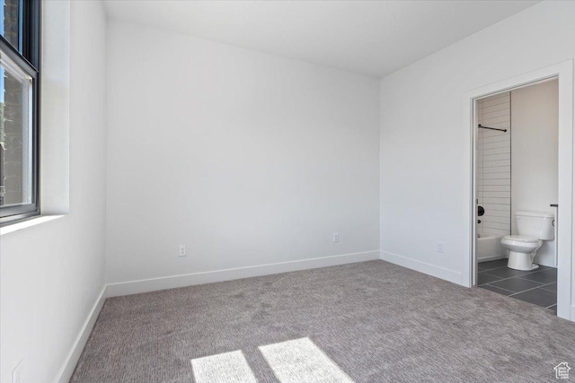 unfurnished bedroom with carpet, baseboards, and connected bathroom