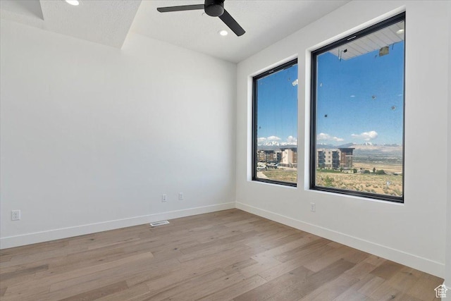 unfurnished room featuring light wood-style flooring, a ceiling fan, baseboards, and recessed lighting