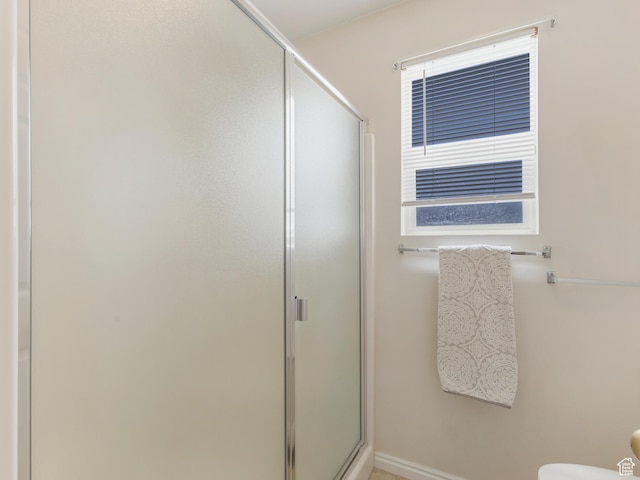 full bath featuring a shower stall, toilet, and baseboards