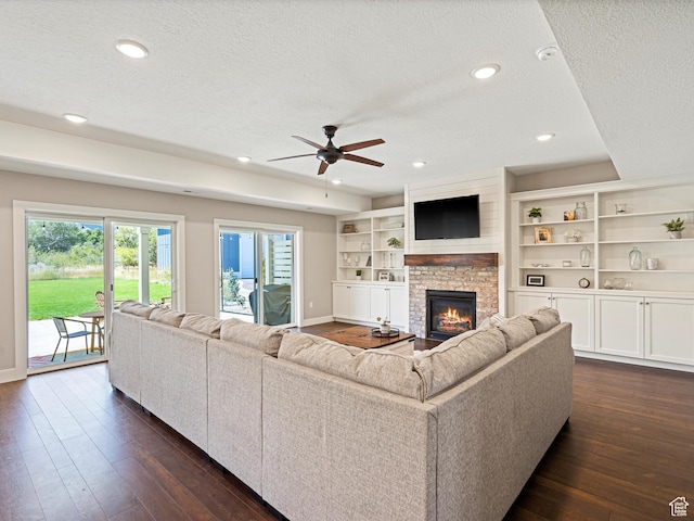 4591 N Abbey Way, Eden, UT 84310 - living room featuring a textured ceiling, dark wood-style floors, baseboards, a fireplace, and ceiling fan