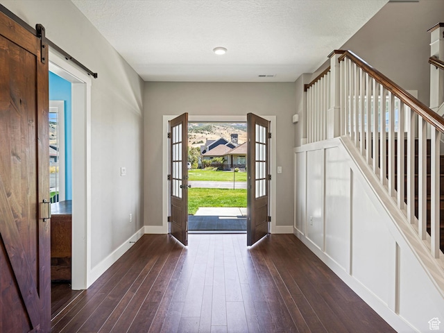 4591 N Abbey Way, Eden, UT 84310 - foyer with dark wood-style floors, baseboards, a barn door, a textured ceiling, and stairs