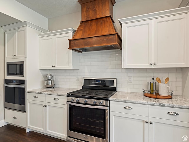 4591 N Abbey Way, Eden, UT 84310 - kitchen with stainless steel appliances, premium range hood, white cabinets, dark wood-style flooring, and decorative backsplash
