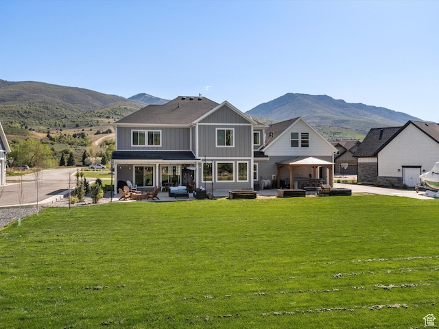 4591 N Abbey Way, Eden, UT 84310 - back of property featuring board and batten siding, a patio, a mountain view, and a yard