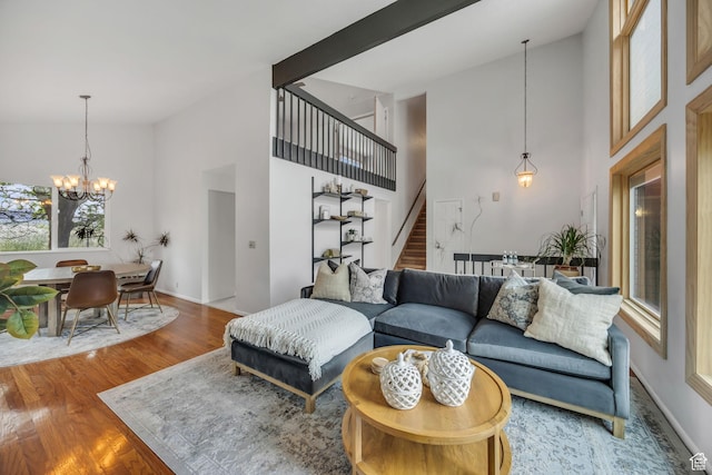 3270 E Danish Hills Cir, Salt Lake City, UT 84121 - living area with high vaulted ceiling, stairway, a chandelier, wood finished floors, and baseboards