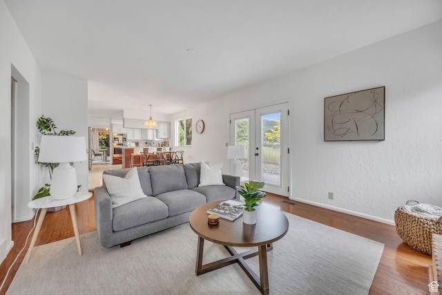 3270 E Danish Hills Cir, Salt Lake City, UT 84121 - living room featuring light wood-style floors, baseboards, and french doors