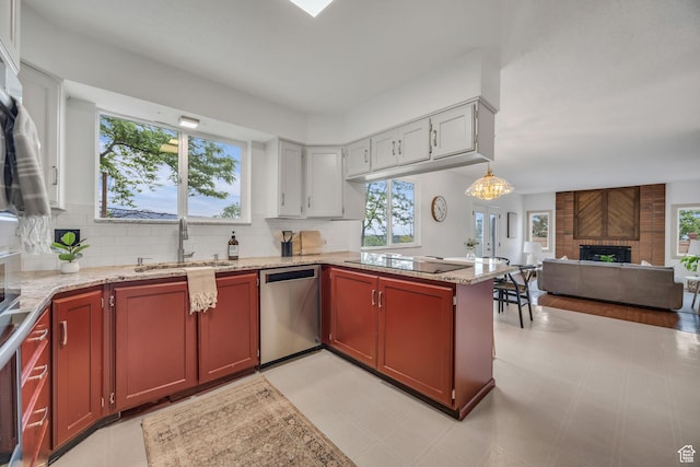 3270 E Danish Hills Cir, Salt Lake City, UT 84121 - kitchen featuring dishwasher, black electric stovetop, a brick fireplace, open floor plan, and backsplash