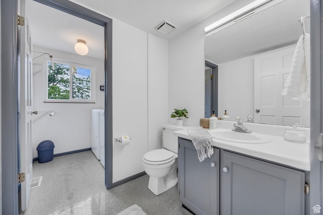 3270 E Danish Hills Cir, Salt Lake City, UT 84121 - bathroom featuring washer and clothes dryer, toilet, vanity, and baseboards