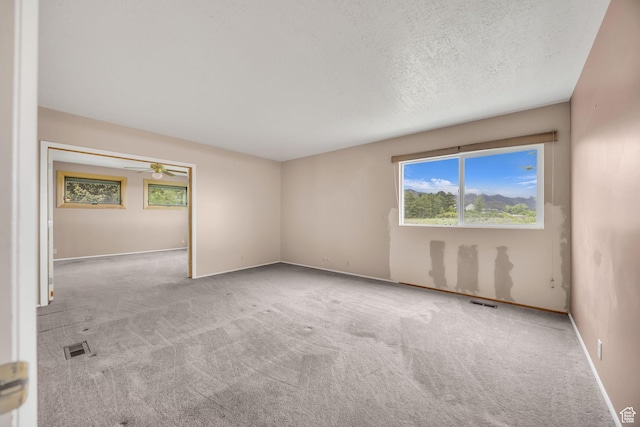3270 E Danish Hills Cir, Salt Lake City, UT 84121 - carpeted empty room with baseboards, a ceiling fan, and a textured ceiling